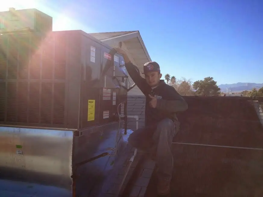 HVAC technician performing Air Duct Cleaning on a rooftop unit in Burlingame